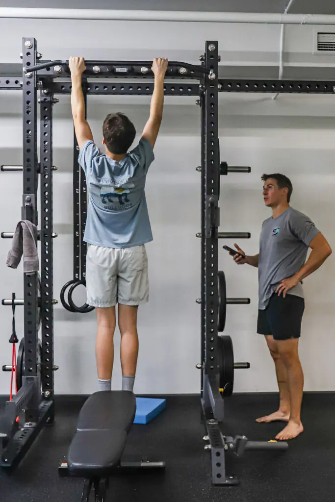 Physical therapist conducting movement assessment with athlete